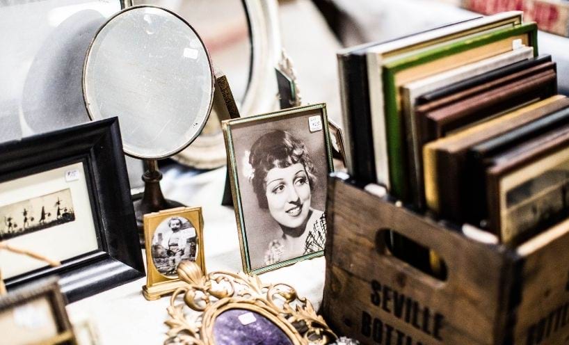 A tabletop with a display of old photos and mirrors
